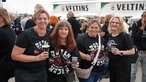 Eine vierköpfige Frauengruppe in Toten-Hosen-Fan-Shirts lächelt in die Kamera.