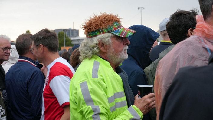 Ein Fan mit einer karierten Kopfbedeckung.