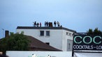 Fans schauen von einem benachbarten Haus auf das Konzert.