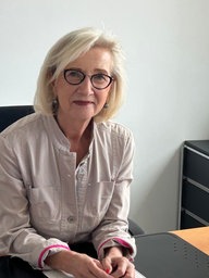 Eine Frau sitzt am Schreibtisch.