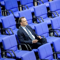 Jens Spahn sitzt alleine zwischen den blauen Stühlen im Bundestag.