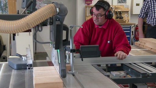 Ein Mitarbeiter der Behinderten-Werkstatt Freckenhorst arbeitet an einer Maschine.