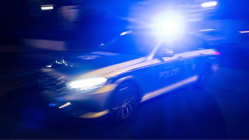 Ein Polizeifahrzeug fährt mit Blaulicht.