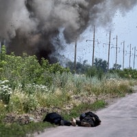 Nahaufnahme eines der Bilder der Ausstellung, welches eine Explosion und tote Menschen auf einer Straße zeigt.