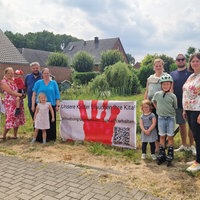 Eltern und Kinder stehen neben einem Schild: "Unsere Kinder brauchen ihre Kita!"
