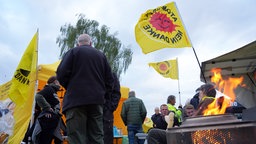 Teilnehmer der Mahnwache mit wärmendem Feuer und einem Versorgungszelt