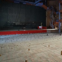 Ein leerer Thatersaal ohne Stühle.