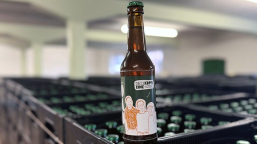 Eine Hödaho-Bierflasche vor unzähligen Kästen
