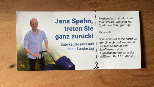 Auf einer Postkarte mit einem Foto von Jens Spahn beim Kinderwagen-Schieben steht: "Jens Spahn, treten Sie ganz zurück".
