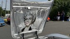 Eine aufgeklappte Motorhaube eines Opel GTs. Auf ihr ist das Bild von Mirilyn Monroe.