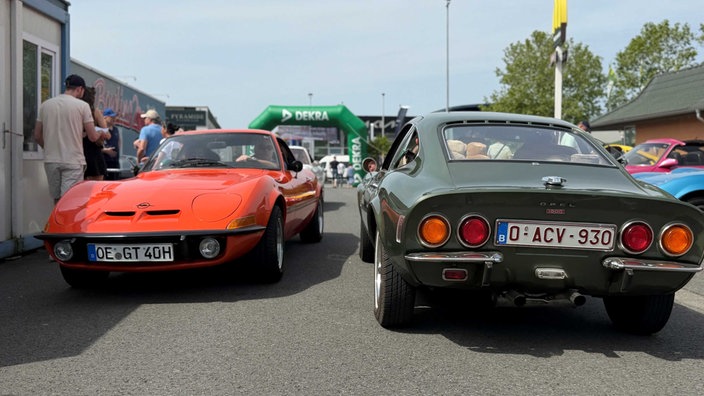 Zwei Opel-Oldtimer, die aneinander vorbei fahren.
