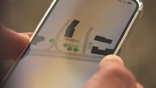 Eine App auf einem Handy, die Straßenkarten mit Parkplätzen anzeigt.