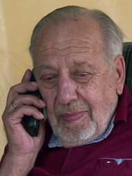Rentner Helmut Krajewski aus Ahaus sitzt auf einem Sessel und telefoniert.