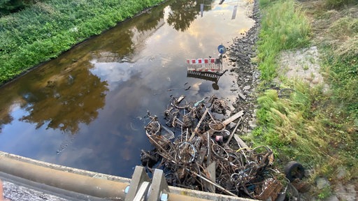 Alte Fahrradleichen liegen verrostet auf einem Haufen in der Bocholter Aa.