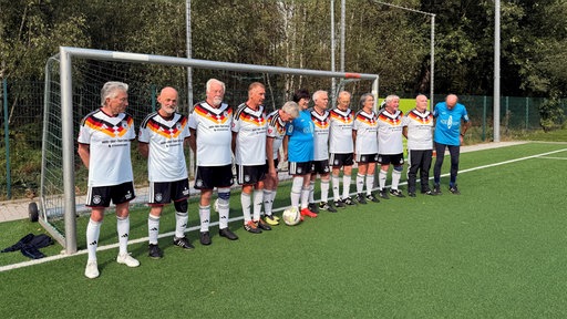 Das Fussballteam steht gemeinsam vor dem Tor.
