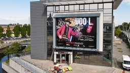 Großes Plakat von Udo Lindenberg zu einer Sonderausstellung im rock'n'popmuseum an einem Gebäude. 