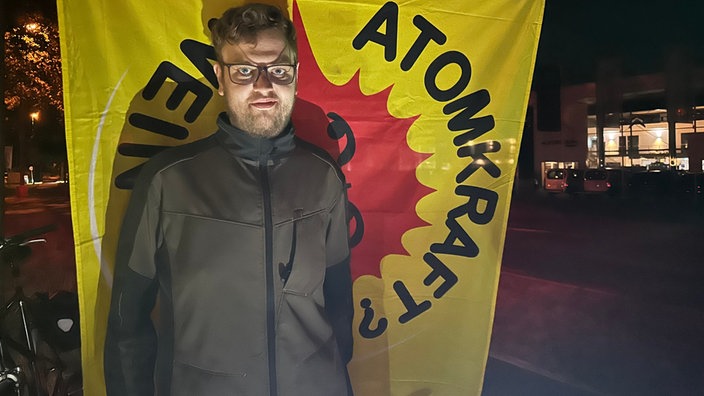 Elias Schmeing aus Ahaus vor einem Banner "Atomkraft? Nein Danke"