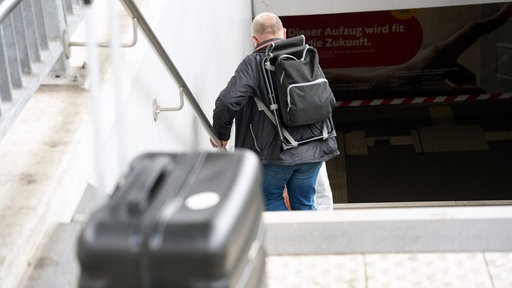 Ein Reisender steigt die Treppe vom Gleis hinunter