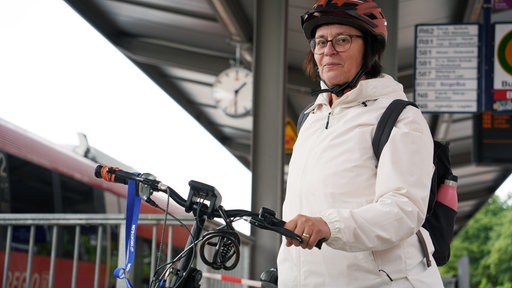 Valeria Okoro-Menzel an einer Bushaltestelle mit ihrem Fahrrad