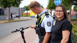 Polizist Steffen Beckenhusen kontrolliert den E-Scooter von Jasmin Usta.