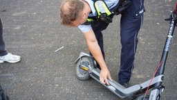 Polizist Steffen Beckenhusen kontrolliert einen E-Scooter.