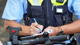Ein Polizist stellt eine Verwarnung aus.