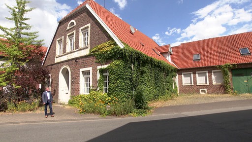 Vor der unter Denkmalschutz stehende Kneipe geht ein Mann.