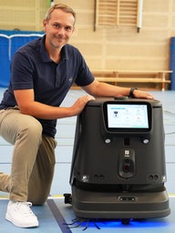 Markus Friehage neben Roboter "Roberta"