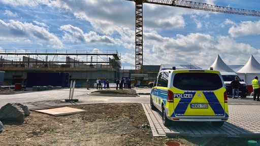Ein Einsatzwagen steht vor dem Baugelände.