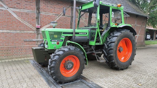 Ein grüner Trecker mit roten Felgen.