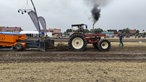 Die Reifen eines Trecker drehen in einem Feld durch