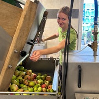 Eine Frau bedient eine Apfel-Maschine.