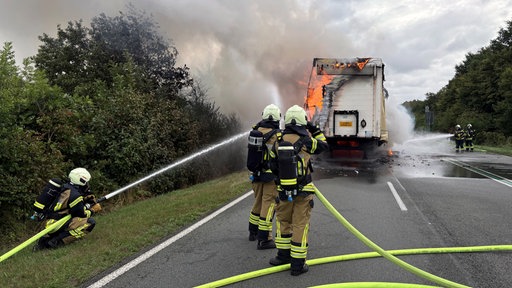 Ein brennender Lkw wird von der Feuerwehr gelöscht.