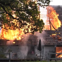 Der Dachstuhl einer großen Scheune steht in Flammen