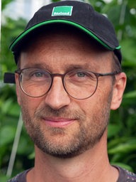 Ein Mann mit Mütze und Brille