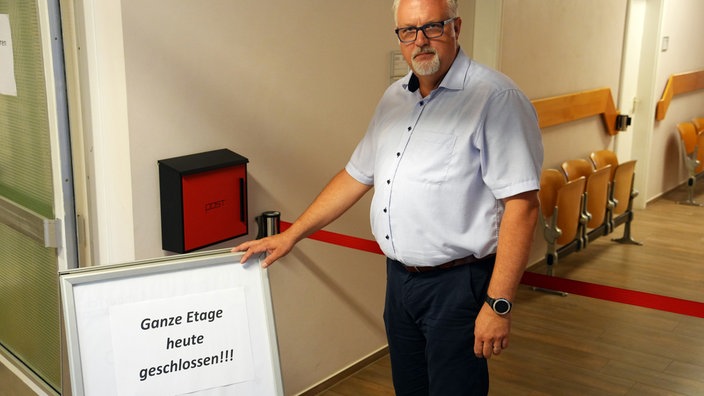 Björn Schilling, Bürgermeister von Lengerich, neben einem "Etage geschlossen" Schild