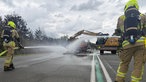 Feuerwehrleute löschen qualmende Wrackteile