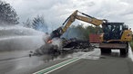 Wrackteile werden auf der Fahrbahn gelöscht