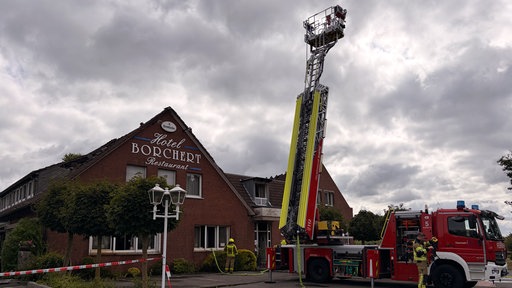 Ein Hubkran von der Feuerwehr steht ausgefahren auf dem Hof des Borchert-Hotels.