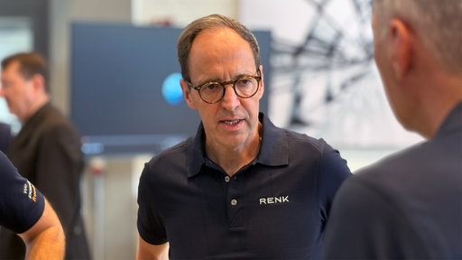 Vorstandsmitglied von Renk, Emmerich Schiller, unterhält sich mit einer weiteren Person.
