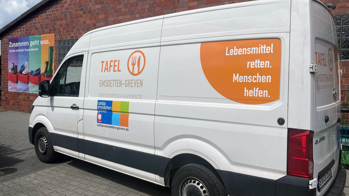 weißer großer Bulli mit der Aufschrift "Tafel Emsdetten Greven" und "Lebensmittel retten. Menschen helfen."