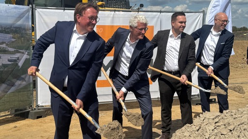 Ibbenbürens Bürgermeister Marc Schrameyer, Geberit-Chef Christian Buhl und andere Männer setzen den Spatenstich für ein neues Logistikzentrum.