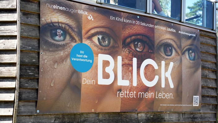 Auf einem Plakat sind mehrere Augen verschiedener Personen zu sehen. Darunter der Schriftzug: "Dein Blick rettet Leben" 