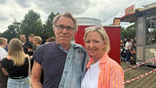 Mann und Frau vor ein paar Menschen im Hintergrund