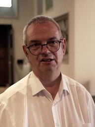 Thomas Hüwe, Pfarrer St. Johannes der Täufer in Rheine, spricht in die Kamera.
