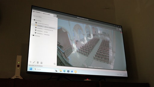 Der Bildschirm der Videoüberwachung zeigt den Kirchenraum.