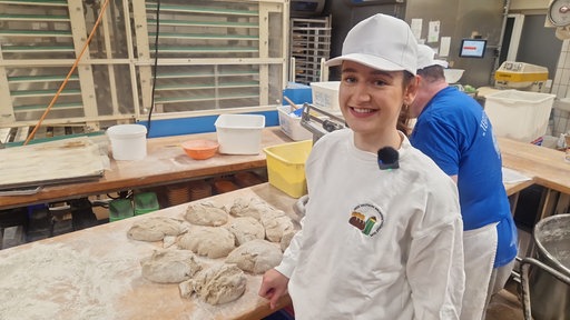 Bäckermeisterin Louisa Hendker steht vor geformtem Brötchenteig