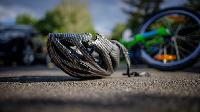 Symbolfoto: Ein Fahrradhelm liegt auf einer Straße.
