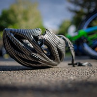 Symbolfoto: Ein Fahrradhelm liegt auf einer Straße.