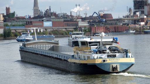 Ein leeres Binnenschiff fährt über einen Fluss
